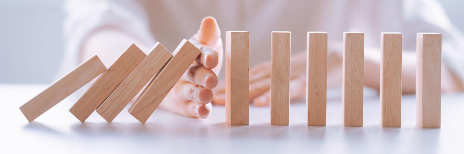 Risiken minimieren bei Elektrische Sicherheit Expertin haltet rechtzeitig eine fallende Reihe bestehend aus Holzsteinen auf